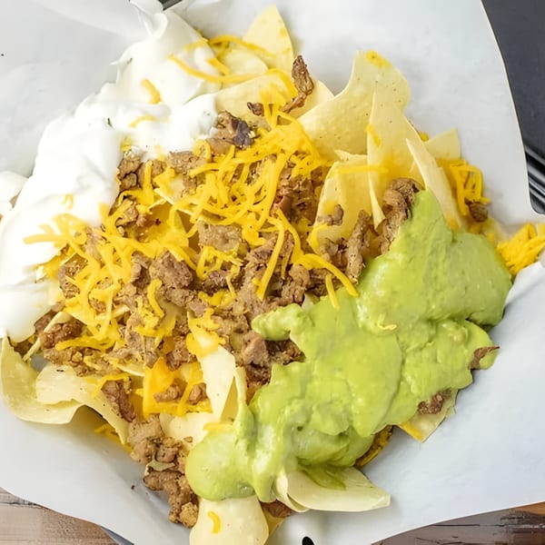 Taco Plus Mexican Grub nachos with ground beef, shredded cheese, sour cream, and guacamole.